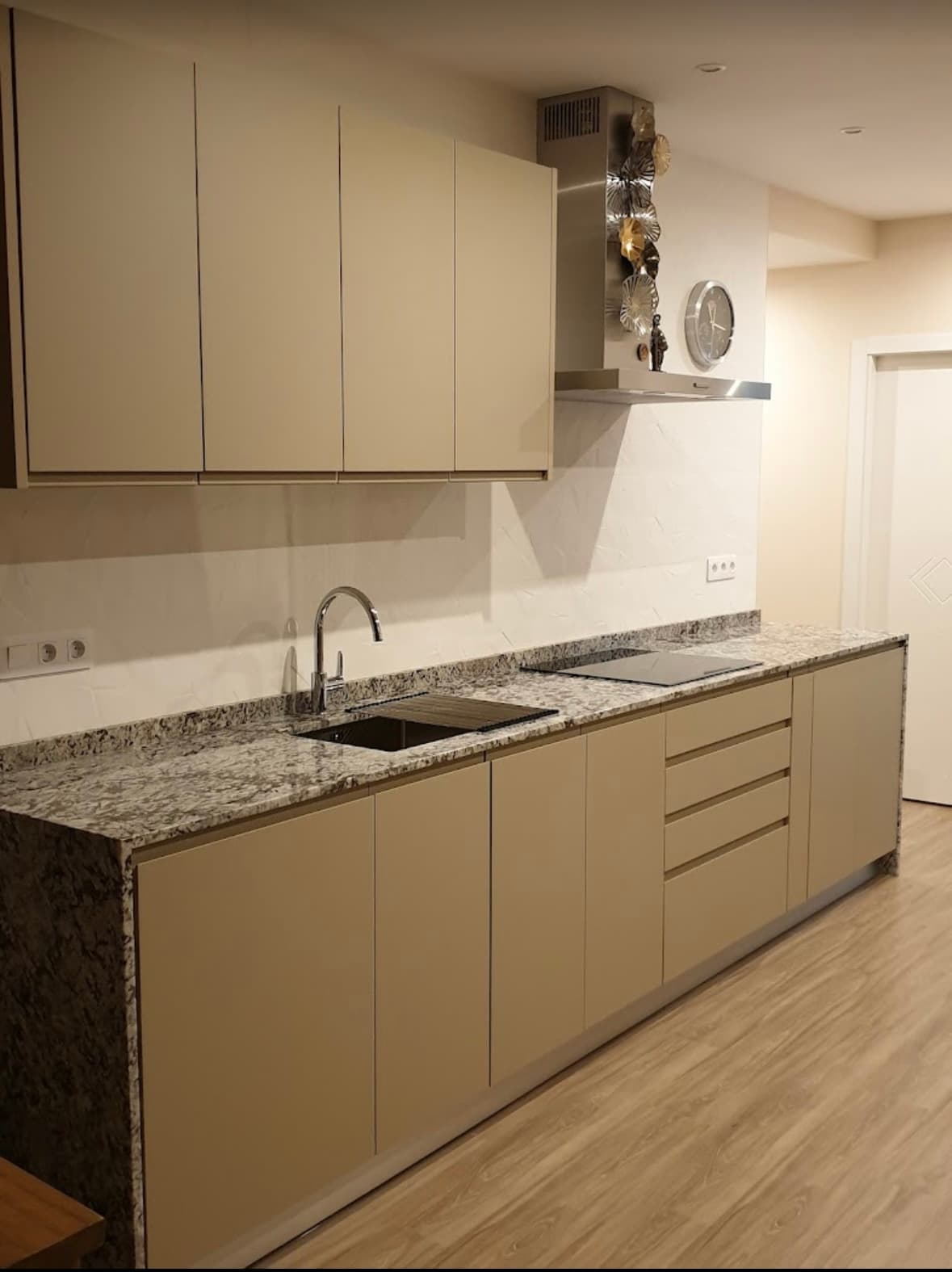 Cocina lineal en tonos beige con encimera de piedra